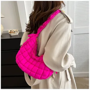 Détail d'un sac matelassé rose vif avec bandoulière froncée porté par un mannequin