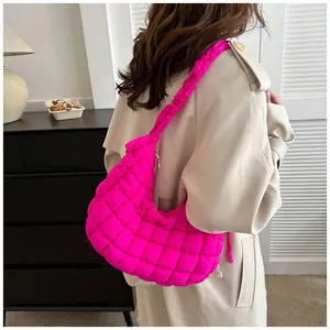 Détail du sac bandoulière rose fuchsia matelassé avec bandoulière froncée et zip en métal