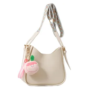 Borsa a tracolla in pelle PU crema con tracolla geometrica e ciondolo a pesca peluche