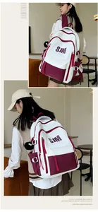 Detalle del bolsillo lateral de mochila blanco y burdeos con hebilla y dije