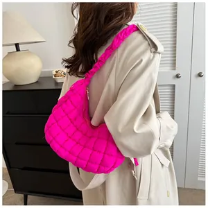 Détail du sac nuage matelassé rose rouge avec coutures en losange et bandoulière