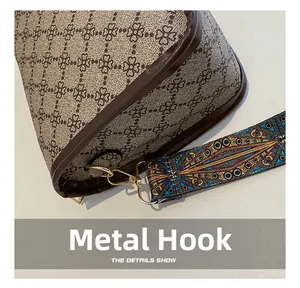 Détail du crochet en métal doré et de la sangle imprimée sur le sac bandoulière rétro