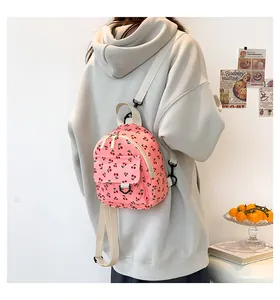 Detail of pink corduroy mini backpack with cherry print and white nylon straps