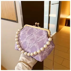 Detail van lavendel tweed tas met parelmoer handvat en gouden metalen framesluiting