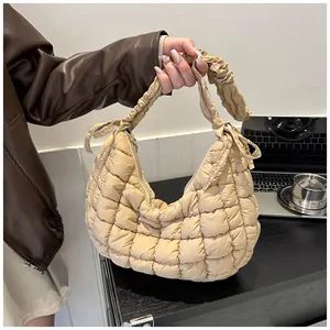 Vue détaillée du sac nuage matelassé beige avec poignée à volants texturée élégante