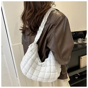 Détail du sac nuage matelassé blanc avec bandoulière à volants en situation de style de vie