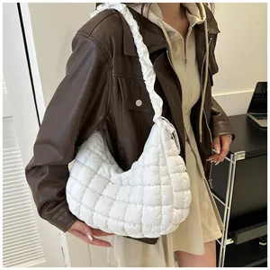 Détail du sac nuage matelassé blanc avec bandoulière à volants porté par un modèle
