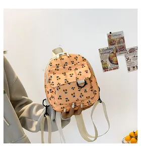 Detail of mini corduroy backpack with cherry pattern and white cotton woven straps