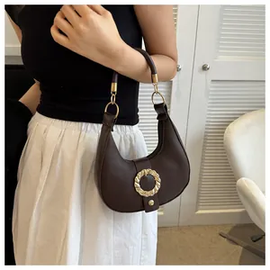 Detail of dark brown retro shoulder bag showing lychee grain texture and gold round buckle