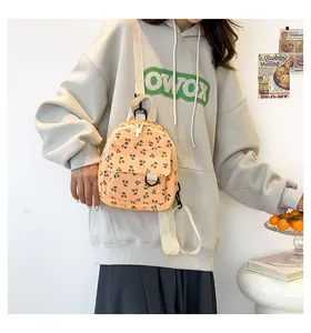 Detail of mini corduroy backpack featuring cherry prints and cream adjustable straps