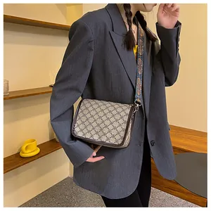 Détail d'un sac bandoulière vintage avec motif jacquard et large sangle brodée