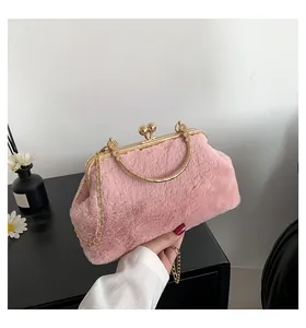 Detail of pink faux fur handbag with gold metal frame and spherical lock closure