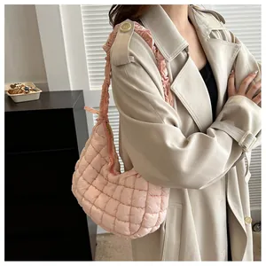 Détail du sac nuage matelassé rose clair avec bandoulière froncée et forme de croissant