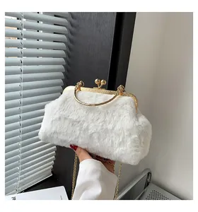 Detailed view of white faux fur handbag with golden metal frame and chain strap