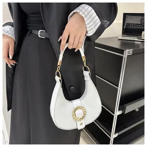Close-up of white crescent shoulder bag with vintage gold metal buckle and pebble texture
