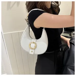 Side view of white hobo shoulder bag featuring a golden circular buckle and lychee texture