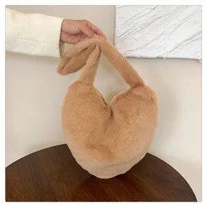 Détail d'un sac à main en peluche en forme de cœur en fausse fourrure camel