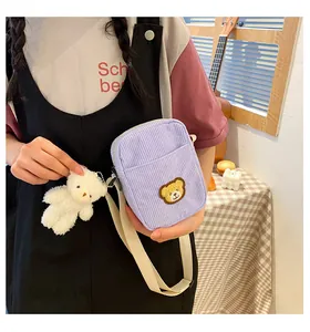 Close-up of lavender corduroy bear crossbody bag featuring a cute plush bear charm