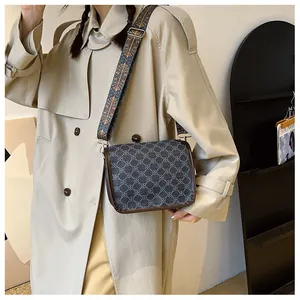 Détail du sac bandoulière vintage avec sangle jacquard et motif géométrique sur mannequin