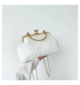 Detail of white faux fur clutch featuring gold metal frame and spherical clasp closure