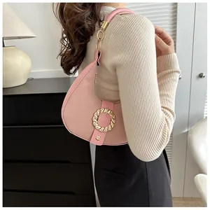 Pink lychee leather hobo bag with round gold buckle shown in a lifestyle setting