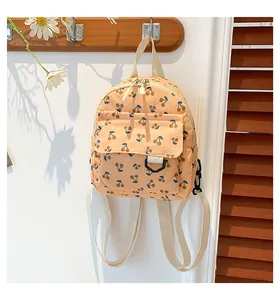 Close-up of corduroy backpack featuring cherry prints and front flap pocket