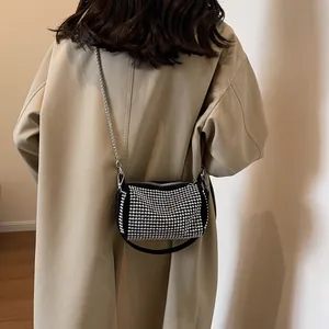 Borsa a tracolla scintillante con strass e catena argentata indossata con trench kaki