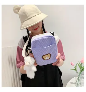 Detail of light purple corduroy crossbody bag with cute bear embroidery and plush charm