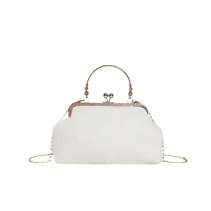 White faux fur handbag with gold kiss-lock clasp and chain strap for winter fashion