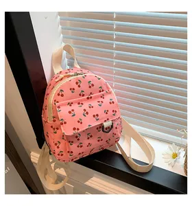 Detail of pink corduroy mini backpack with cherry print on a white windowsill