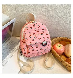 Detailed macro view of pink corduroy backpack with cherry pattern and buckle pocket