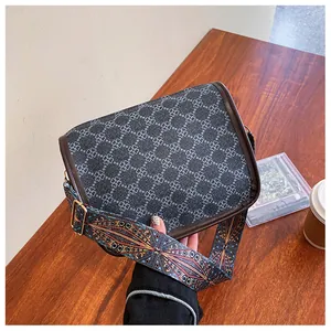 Gros plan d'un sac bandoulière rétro avec motif trèfle et sangle tissée colorée