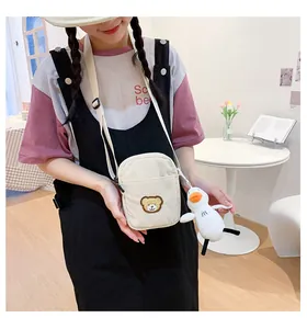 Detail of corduroy crossbody bear bag with duck charm showing adjustable shoulder strap
