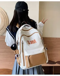 Detalle de la mochila minimalista en blanco y marrón con estampado de letras SJM