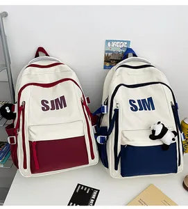 Detalle de mochilas escolares con estampado de letras SJM y diseño de contraste