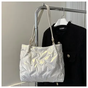 Détail d'un sac cabas matelassé blanc perle avec coutures en V et anneaux dorés