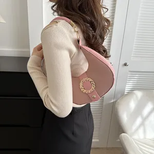Pink crescent underarm bag in pebble leather with a stylish golden ring buckle