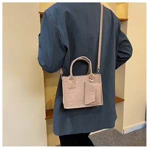 Detail of apricot embossed felt tote bag with detachable coin purse and shoulder strap