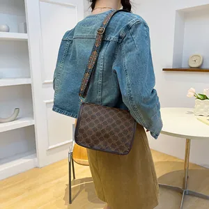 Sac bandoulière rétro marron avec large sangle ethnique porté par un mannequin femme