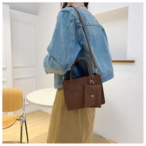 Detail of dark brown embossed felt handbag featuring a matching small coin purse attachment
