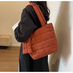 Dettaglio della borsa tote trapuntata color caramello con cuciture a nido d'ape