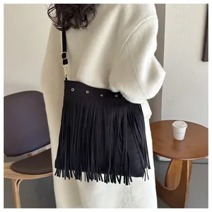 Detail of bohemian black fringe shoulder bag with matte suede texture and metal ring