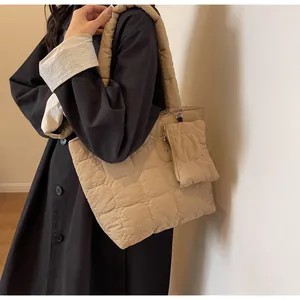 Dettaglio della borsa tote trapuntata beige con mini pochette abbinata e trama soffice