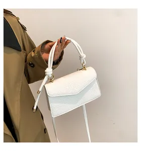 Dettaglio della borsa bianca con trama intrecciata, manico a nodo e finiture dorate