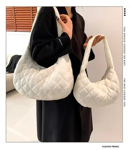 White quilted puffer hobo bags in small and large sizes shown on a model in black coat