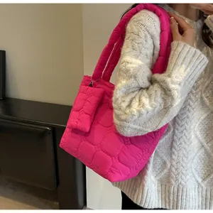 Dettaglio della borsa tote in nylon trapuntato rosa acceso con mini pochette e texture soffice