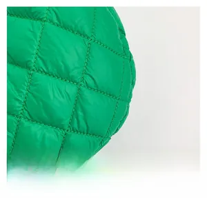 Detail shot of bright green quilted nylon fabric with classic diamond stitching patterns