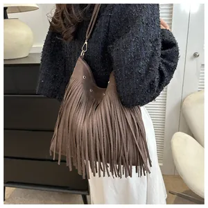 Detail of coffee brown tassel shoulder bag featuring soft suede texture and silver grommets