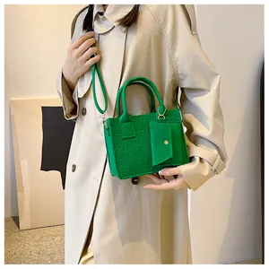 Detail of green embossed felt tote bag with shoulder strap and mini coin purse charm