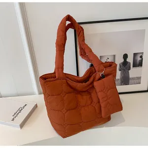 Dettaglio della borsa tote trapuntata con pochette coordinata in arancione caramello